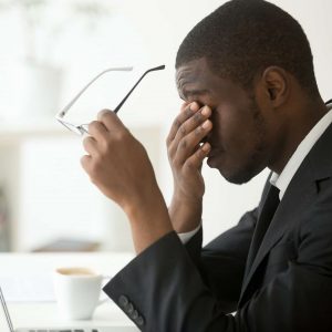 Man experiencing eye strain after looking at his computer